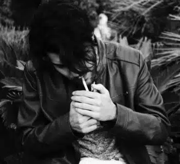 grayscale photo of man holding lighter